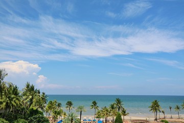 Beautiful view of the sea with the coconut trees, blue sky and white clouds in summer time. Nature concept. 