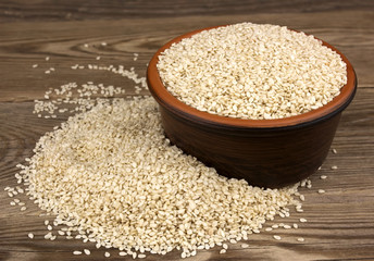White sesame in a bowl on wooden background