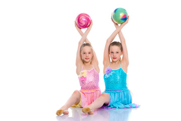 Girls gymnasts perform exercises with the ball.