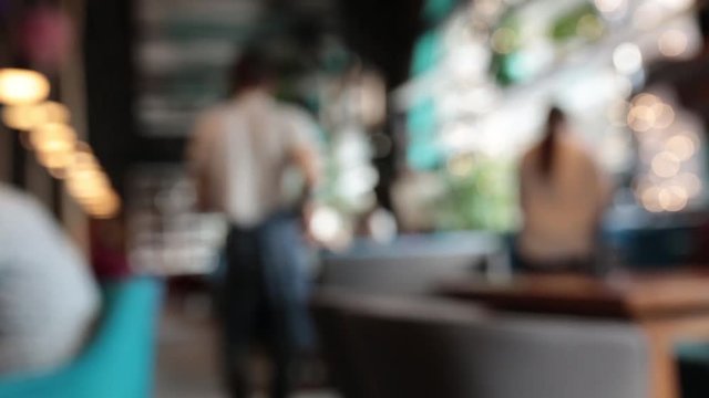 Defocused background - a group of people is sitting in a modern restaurant.