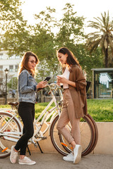 Obraz premium Beautiful women friends outdoors with bicycles