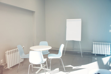 Empty seminar room with chairs and whiteboard for a presentation. Flipchart in empty poor office