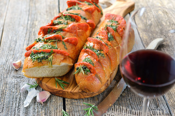 Überbackenes Baguette mit  Kräuterbutter und scharfer Chorizo Salami mit Tempranillo Rotwein serviert – Spanish snack: Baked bread with herb butter and hot Chorizo salami served with red wine