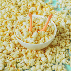doll girl's hands in plate with popcorn.  Creative summer concept of cinema