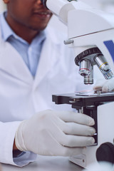 Modern equipment. Smart professional researcher working and touching his modern sophisticated microscope