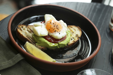 Fried egg with avocado and tomato on toast