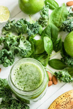 Green Detox Smoothie or Juice in bottle jar. Fresh summer detox drink with kale, broccoli, apple, spinach and lime. Top view