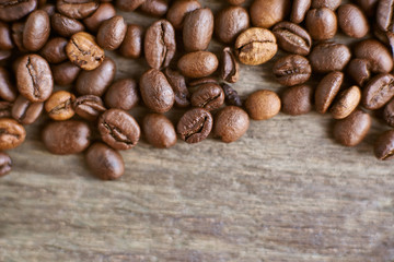 Roasted coffee beans on rustic wooden background. Food ingredients, top view, space for text