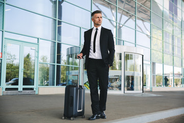 Confident mature businessman standing outside the airport