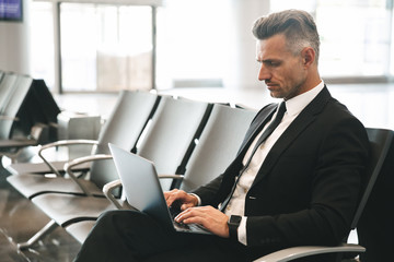 Fototapeta premium Confident businessman using laptop computer
