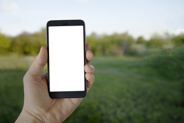 Modern Smartphone Device in man hand on summer green background. Mock up