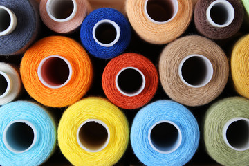 background of sewing thread in different colors.