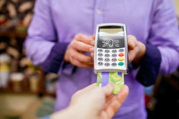 Picture of buyer pays with smartphone near seller man with terminal