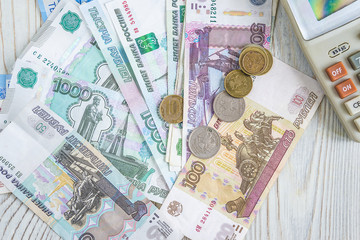 Hand lens and calculator on russian rubles and coins banknotes and coins