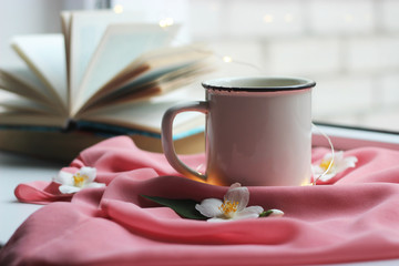 lights, a cup and a book on the windowsill. Jasmine tea. insta, minimalism, comfort.