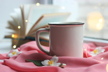 lights, a cup and a book on the windowsill. Jasmine tea. insta, minimalism, comfort.