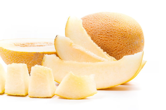 Close up view of whole, half and sliced honeydew melon tropical fruit isolated on a white background.