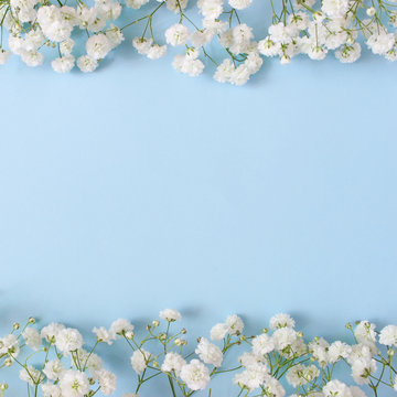 Styled stock photo. Feminine wedding desktop mockup with baby's breath Gypsophila flowers on blue background. Empty space. Floral frame, web banner. Top view. Square icture for blog or social media.
