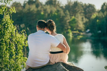 loving couple is sitting hugging looking to the sun