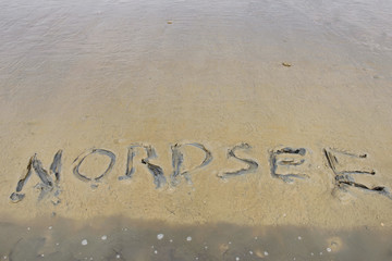 Low tide beach of north sea with the word 