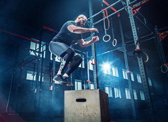 Man jumping during exercises in the fitness gym. CrossFit.