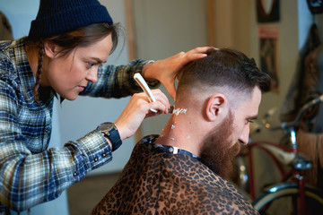 Photo of hipster man getting haircut by hairdresser