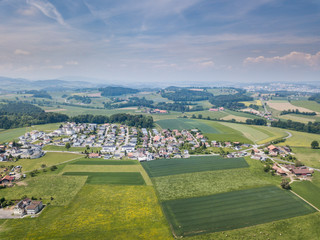 Aerial view of rural village in Switzerland with building and rooftop from above on a beautiful warm summer day