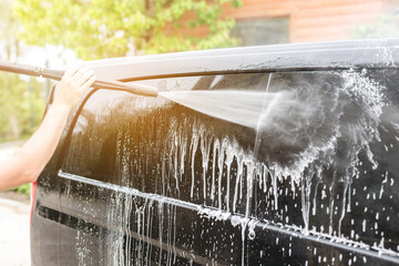 Manual car wash. Washing luxury vehicle with high pressure water pump.Automobile  cleaning self...