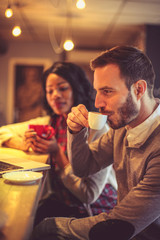 Two young colleagues at cafe Working on laptop.