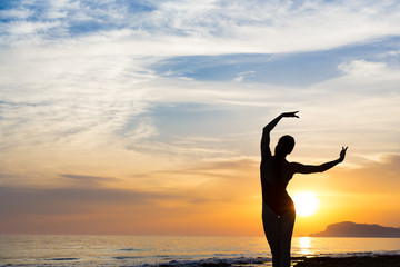 Sunset yoga woman meditation on Ocean coast