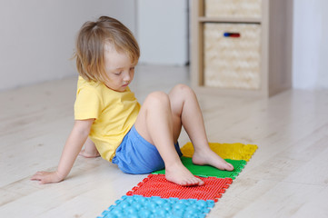 The kid plays with massage multi-colored puzzles.