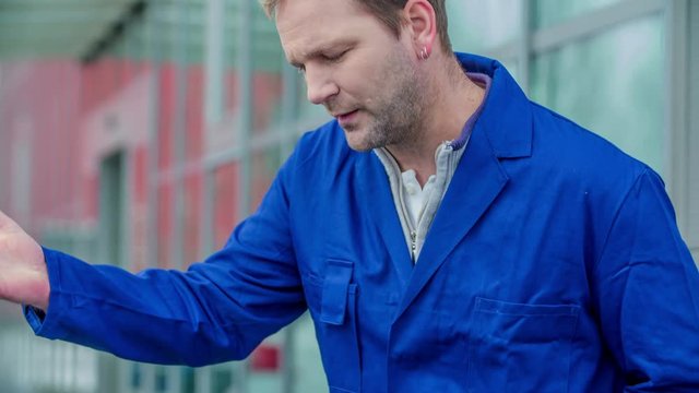 A man is annoyed when he sees a crack on the front window of the car.