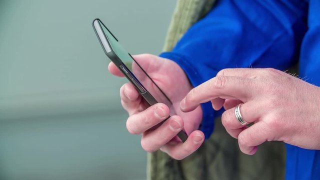 A man is swiping through his messages on his phone.
