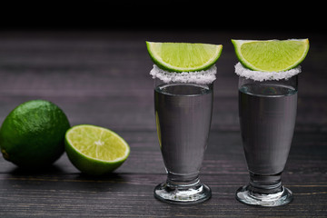 Two shot silver  tequila a black wooden background
