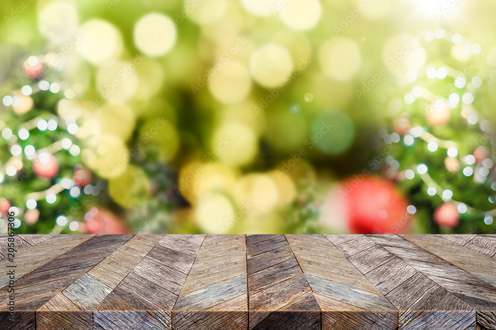 Leinwandbilder empty dark brown wood table top with abstract blur christmas tree red decor ball and snow fall backg