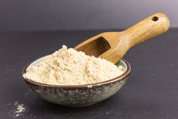 powdered maca root in a bowl with wooden scoop