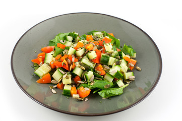 Green plate with a healthy salad isolated on white background