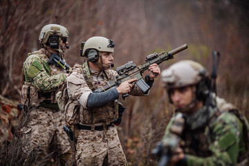 soldiers or private military contractors aiming with rifle. war, army, weapon, technology and...