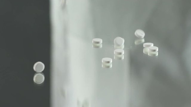 Pills falling on table, experimental placebo drugs, pharmaceutical business