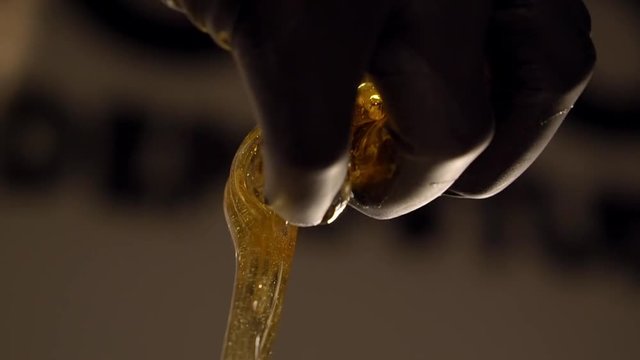 Close-up of beautician hand with sugaring paste. Master is turning it and rumpling