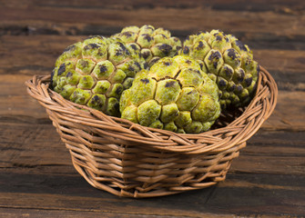 Sweet And Healthy Fruit Custard Apple Also Know as Sitafal, Sweetsop, Annona Squamosa, Sugar Apple, Sitaphal or Anona in Basket on Wooden Table