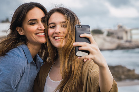 women taking selfie on sea background