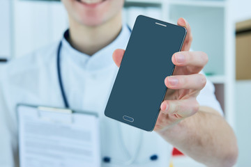 Male doctor's hand showing a blank smart phone screen.