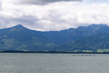 River side of a big lake in front of big mounts in bavaria under grey clouds 