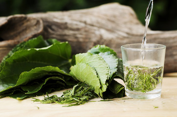 Close up of Mulberry green tea with pouring hot water on to glass