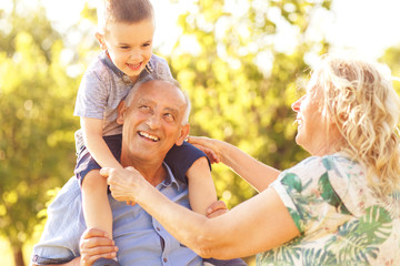Grandparents with grandson enjoying time together in park.