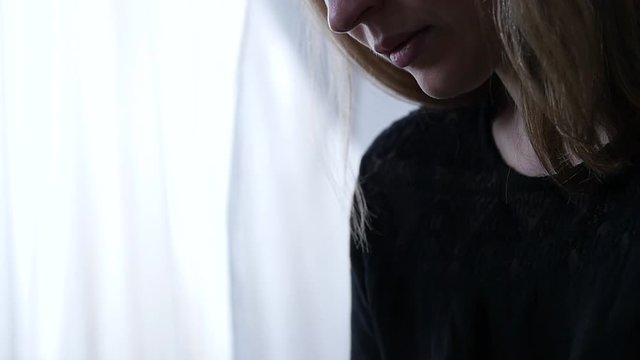 sed young woman sitting sitting on a window background and writes in her diary. adolescent experiences. slow motion
