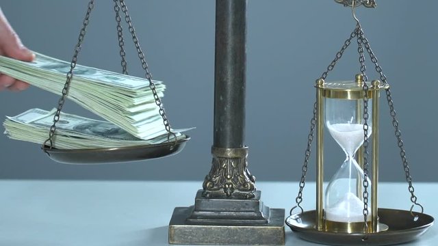 Bundle of money and sandglasses on scales, time is precious, values of life