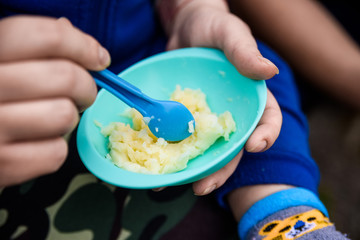Obraz na płótnie Canvas Feeding baby with food in small plastic plate