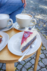 Street cafe in Weimar, Germany. Two cups of coffee latte and a piece of cake